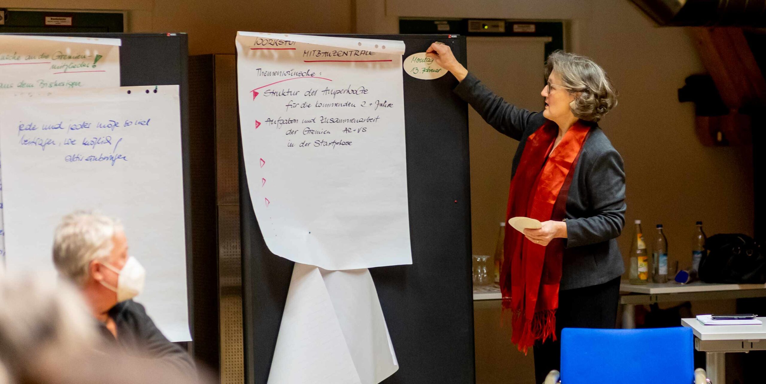 Workshop zur Entwicklung der AmperWoGe: Teilnehmerin erläutert Themen und Ergebnisse am Flipchart während einer gemeinsamen Arbeitsrunde.